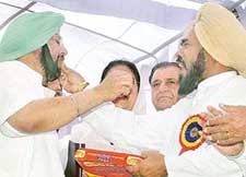 Punjab Chief Minister Amarinder Singh and PPCC President Shamsher Singh Dullo offer sweets to each other during the function to mark the formation of the new district of SAS Nagar on Friday