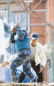 A Nepalese policeman beats a pro-democracy activist with a stick at Balaju in Kathmandu on Sunday.