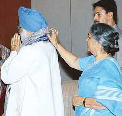 Prime Minister Manmohan Singh’s wife Gursharan Kaur adjusts her husband’s shawl during the presentation of Usha Uthup’s music album on Tsunami to the Prime Minister on Tuesday.