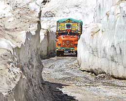A truck carrying supplies passes through walls of snow after the Srinagar-Leh highway is thrown open for traffic in Zojila, 108 km east of Srinagar, on Sunday. The 443-km-long Srinagar-Leh highway was opened by Army authorities to traffic after remaining snowbound at Zojila Pass, 3530 metres above sea level, for more than six months.