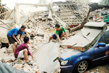 Residents try to remove concrete rubble from the top of their car after a strong earthquake rocked Yogyakarta, southern coast of Indonesias Central Java, on Saturday