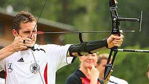 German forward Miroslav Klose aims as the German national football team practises archery on a free morning in Berlin on Wednesday.