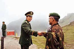 A Chinese army officer (left) exchanges greetings with his Indian counterpart following a meeting among the officers as they stand on the border of Nathu La, some 52 km east of Gangtok on Wednesday.