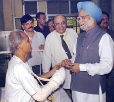 Prime Minister Manmohan Singh meets a victim of Tuesdays serial bomb blasts at Lokmanya Tilak Hospital in Mumbai on Friday.