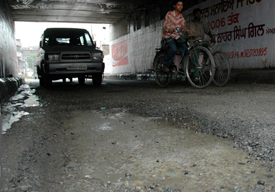 A huge crater formed on the road passing under Damoria bridge due to waterlogging in Ludhana on Friday