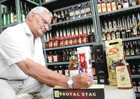 A liquor contractor, Mr Sat Pal, signs on a case of liquor.