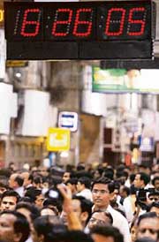 Commuters stand still during a two-minute long remembrance at Churchgate railway station in Mumbai on Tuesday. 