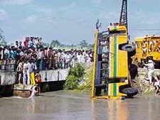 The ill-fated school bus, which fell into a canal, is lifted by a crane in Sonepat on Tuesday. Six schoolchildren were killed in the accident