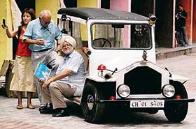 Ravi Mann (seated) relaxes after years of labour that he put in to make the first-ever replica of a vintage car
