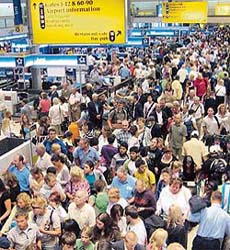 Passengers queue at the departure area of terminal One of Heathrow Airport in London