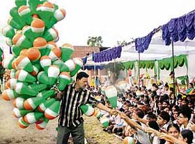 A man distributes balloons to children at an Independence Day function in Mohali