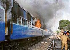 Firefighters try to extinguish the flames in a train coach at Secunderabad, in Andhra Pradesh