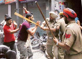 Policemen cane charge a group of Sikh youngsters, in Jalandhar