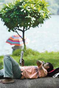 A man reads a newspaper as he lies besides a lake in Kolkata. Environmentalists are raising their concern on the encroachment of wetlands and small water bodies due to the increasing real estate boom in the country’s major conurbations. The real estate aggression on waterbodies has prompted the Calcutta Metropolitan Planning Committee (CMPC) to ask the civic authorities to protect and preserve all wetlands in the city. The committee also decided that every development proposal relating to the wetlands has to be approved by the Environment Department.