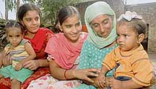 Devinder Kaur poses with one and a half year old son Gaganpreet on her lap