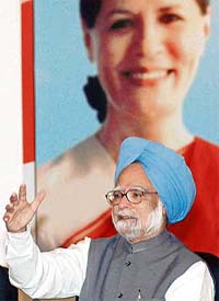 Prime Minister Manmohan Singh speaks in front of a picture of Congress president Sonia Gandhi during a press conference at the end of a Chief Ministers' conclave in Nainital