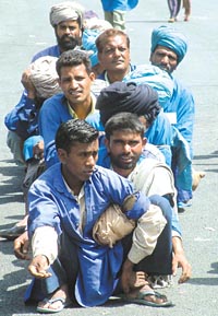 Indian porters wait for their turn to carry baggage arriving from Pakistan at the Wagah joint check post.