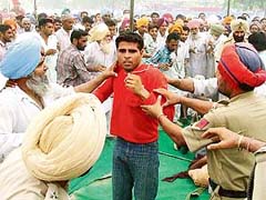 Protesting unemployed B.Ed teachers being taken away from a public meeting in Jhunir