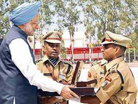 Prime Minister Manmohan Singh presents the Prime Minister's Baton and Home Ministry Revolver to Nishant Kumar Tiwari during the passing-out parade of the 58th batch of IPS Probationers at Sarder Vallabhai Patel National and Police Academy, in Hyderabad on Thursday.
