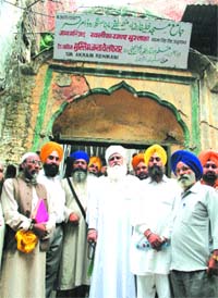 Makdoom Chan Pir Qadri and devotees at the mosque which shares a wall with the Jallianwala Bagh.
