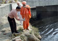 Baba Balbir Singh Seechewal helps a PAU employee take water sample from Budha Nullah in Jamalpur, Ludhidna, on Monday.