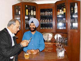 Col A.P.S. Gill entertains a guest in his bar.