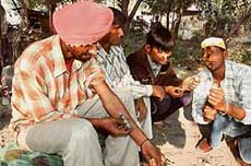 Intravenous drug users (IDUs) inject themselves in a public park at Ludhiana. 