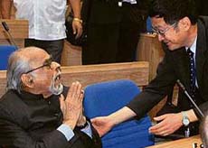A Chinese official tries to molify former Prime Minister I.K. Gujral during the Chinese President Hu Jintao keynote address to Indian and Chinese delegations at Vigyan Bhawan