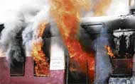 A compartment of a train burns after it was set on fire by a mob near Ulhasnagar railway station, on the outskirts of Mumbai, on Thursday