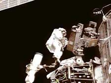 Mission specialist Sunita Williams rides the shuttle robotic arm during a spacewalk on Saturday