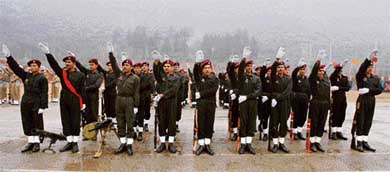 Commandos of Jammu Kashmir Police raise their arms while taking oath during a passing out parade in Sheeri, 60 km north of Srinagar, on Wednesday