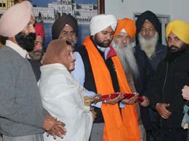 Nimrat Sarup Singh who saved the life of an old woman being honoured by officials of the United Sikhs