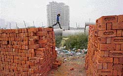 A labourer breaks a concrete slab at a construction site for residential buildings in Ghaziabad. India’s real estate market is in an overdrive as developers snap up land to build malls and housing enclaves, but high prices and opaque rules make it hard for first-time buyers to land a dream home.