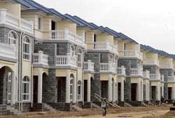 A painter walks in a villa area in Huai’an, Jiangsu province. In the latest move to promote the sale and construction of small apartments in the booming real estate market, China is considering levying a tax on the building of big apartments.