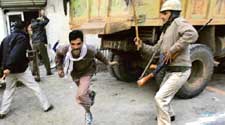 A policeman chases a man with a lathi after residents of Nithari village fought pitched battles with the police on Monday outside the residence of a businessman who, along with his servant