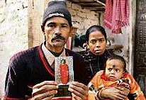 Sonu Sarkar holds a photograph of his missing daughter Pinky while posing with his wife and another child at their residence in Noida on Tuesday.