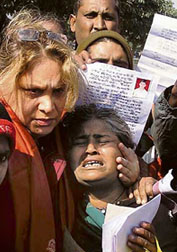 A social activist tries to console a woman, whose child is missing, at Nithari village in Noida on Wednesday. 