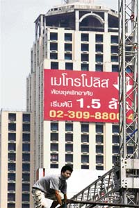 A Thai worker climbs on an iron bar in front of condominium building in Bangkok