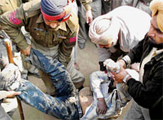 Police personnel lift the body of SAD worker Dilbag Singh, who was allegedly shot dead by Congress workers near Beas in Amritsar district on Monday. 