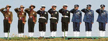 Buglers of inter-services salute as they pay homage at the memorial of Mahatma Gandhi, on the occasion of his 59th death anniversary, in New Delhi