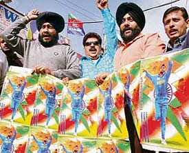 Members of the Lok Janshakti Party burn posters of cricketer Harbhajan Singh in protest against his campaign for a Congress candidate despite being a government employee, in Jalandhar