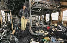 An NSG officer collects samples from the charred carriages of Samjhauta Express near Panipat