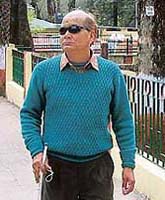 Visually-impaired Prashant Dabral goes to cast his vote at a special polling booth