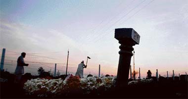 Graves of unidentified victims of the Samjhauta Express train blasts are silhouetted against the setting sun after a mass funeral ceremony at Mehrana village outside Panipat