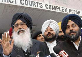 Punjab Chief Minister Parkash Singh Badal and his son Sukhbir come out of the court of the special judge after the framing of charges against them in Ropar