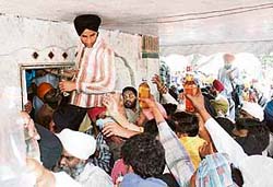 A large number of devotees at the tomb of Baba Rode on the Amritsar-Fatehgarh Churian road offer liquor as “ prasad” on the first day of the three-day fair