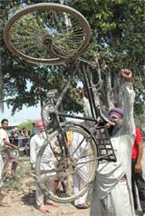 A farmer lifts a bicycle with his teeth in Amritsar.