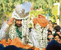 Abhishek Bachchan gestures as he leaves his residence for his wedding to actress Aishwarya Rai in Mumbai.