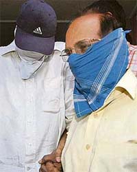 Sunder Lal (left) and Rajendra Singh, who claims to be suspended BJP MP Babubhai Kataras PA, being taken to a court from the Delhi police Crime Branch office in New Delhi