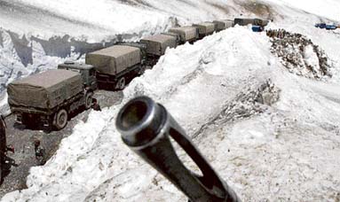 HIGHWAY REOPENS: An Army soldiers gun is partially visible on a ridge above a convoy carrying supplies for soldiers through the Zojila Pass, 108 km north Srinagar